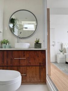 a bathroom with a sink and a mirror at Nala Host- 2BR Beachfront Apartment in Male City