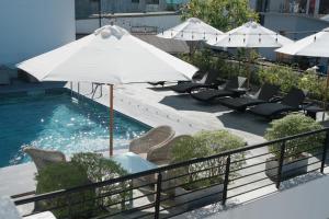 a pool with chairs and an umbrella on a balcony at Rosaleen Boutique Hotel in Hue