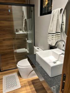 a bathroom with a sink and a toilet and a shower at Studio Casa21 - Moderno e aconchegante in Cáceres +16 photos