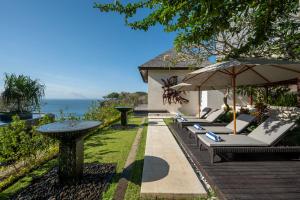 ジンバランにあるBy The Cliff Bali Villaの海の景色を望むラウンジチェア1列