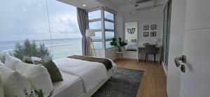 a bedroom with a bed and a large window at Nala Host- 2BR Beachfront Apartment in Male City