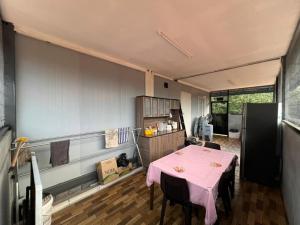 a kitchen with a pink table and chairs in a room at Homestay D'Pengkalan in Masjid Tanah