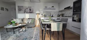 a kitchen and living room with a table and a couch at Nala Host- 2BR Beachfront Apartment in Male City