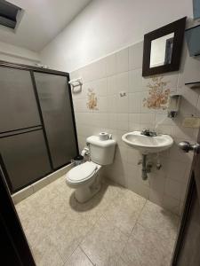 a bathroom with a toilet and a sink at La Casona Hostal in Pereira