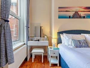 a bedroom with a bed and a desk next to a window at 2 Bed in Swanage 90116 in Swanage
