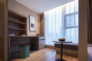 a living room with a table and a large window at Mercure Xi'an Daming Palace in Xi'an