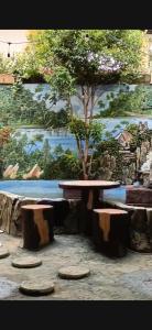 Un cuadro de una mesa y un árbol en una habitación. en Villa Fathan bukit cipendawa, en Cianjur