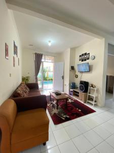 una sala de estar con un sofá y una mesa en Villa Fathan bukit cipendawa, en Cianjur