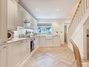 a kitchen with white cabinets and a staircase at 2 Bed in Cockermouth 95716 in Broughton Moor +15 photos