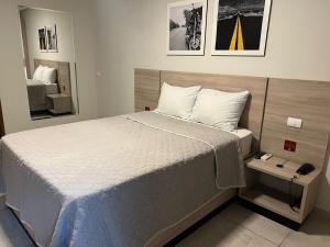 une chambre avec un lit et un miroir dans l'établissement Star Hotel Limoeiro, à Limoeiro