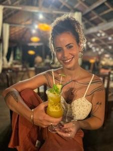 a woman is holding a drink with a straw at TerrAmor Ecoliving in Alter do Chao