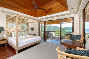 ein Schlafzimmer mit einem Bett und einem Tisch und Stühlen in der Unterkunft Katamanda Villa Allegra 5 bedroom Seaview villa in Kata Beach + 65 Fotos