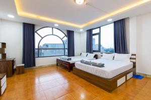 Dĩ AnHotel Hoa Cúc Phương Dĩ An - Bình Dương的一间有大窗户的房间里有两张床