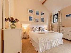 a bedroom with a white bed with a vase of flowers on it at 2 Bed in Sedgehill 96237 in Sedghill
