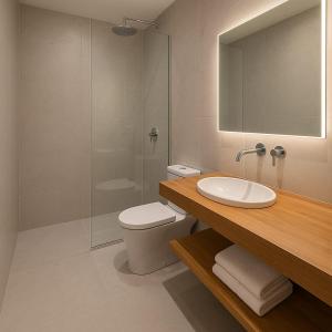 a bathroom with a sink and a toilet and a mirror at Hosteria Alma de Patagonia in El Chalten