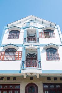 un grand bâtiment blanc avec des fenêtres rouges dans l'établissement Thanh Tâm Hotel, à Cần Thơ