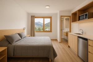a hotel room with a bed and a kitchen at Hosteria Alma de Patagonia in El Chalten