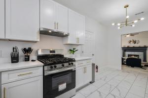 a kitchen with white cabinets and a stove top oven at Modern 3BR in Bishop Arts Walk to Shops in Dallas