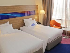 a hotel room with two beds and a chair at Novotel Taiping in Taiping +76 photos