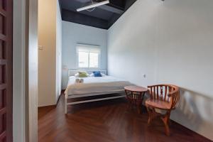 a bedroom with a bed and a table and chairs at Urbanview Hotel The Tang Balikpapan by RedDoorz in Balikpapan +51 photos
