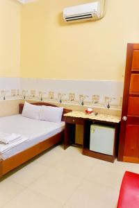 1 Schlafzimmer mit einem Bett und einem Schreibtisch mit Klimaanlage in der Unterkunft Bình Minh Hotel Ninh Thuận in Ninh Hải