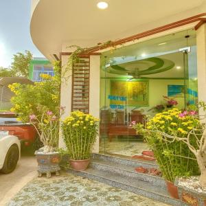 ein Haus mit Glastür und einigen Topfpflanzen in der Unterkunft Bình Minh Hotel Ninh Thuận in Ninh Hải