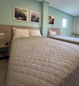 - un grand lit dans une chambre avec 2 lits dans l'établissement Star Hotel Limoeiro, à Limoeiro