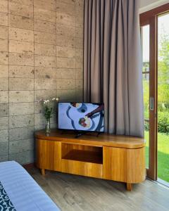 a tv on a wooden cabinet in a bedroom at Ersanea Villas Seseh in Canggu