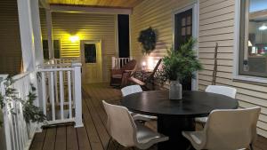 un patio avec une table et des chaises sur un porche dans l'établissement Secluded Farmhouse Near Okemo, Bromley, Sunapee, à Rockingham