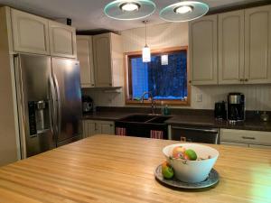 - une cuisine avec un bol de fruits sur une table en bois dans l'établissement Secluded Farmhouse Near Okemo, Bromley, Sunapee, à Rockingham