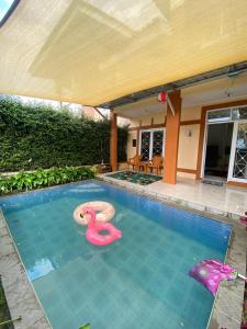 a swimming pool with a pink swan in the water at Villa Fathan in Tjiandjur