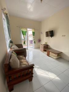 a living room with a couch and a tv at Villa Fathan in Tjiandjur