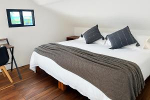 a bedroom with a large white bed with black pillows at Ocean & Marina views,Affordable,Spoil yourself! in Puerto Aventuras