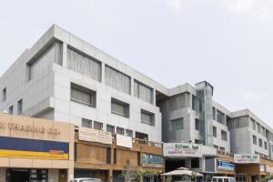 a large white building with cars parked in front of it at Palette - Silver Leaf in Vapi