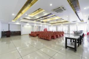 a large room with red chairs and tables in it at Palette - Silver Leaf in Vapi