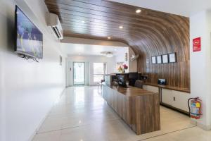 a lobby with a desk and a tv in a building at Palette - Silver Leaf in Vapi