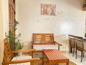a dining room with chairs and a table and a bench at The Beach House Bucana Homestay in El Nido