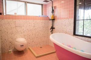 a pink bathroom with a tub and a toilet at Shanghai Bund City Union Hotel Apartment in Shanghai +41 photos