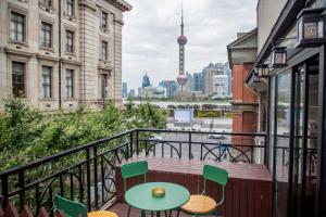 a balcony with a table and chairs and a view of the city at Shanghai Bund City Union Hotel Apartment in Shanghai
