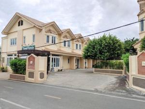a building on a street in front of a road at Romruedee Resort in Sattahip