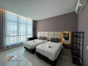 a bedroom with two beds and a large window at Stirling Homestay by Evernent in Miri +25 photos