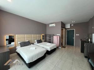 a bedroom with two beds and a kitchen in it at Suites Homestay by Evernent in Miri