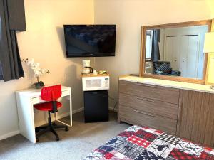 Un dormitorio con una cama, un espejo y un escritorio. en Cozy Attitash Getaway-Hotel Room-Pool-Hot Tub, en Bartlett