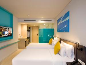 a bedroom with a white bed and a tv at ibis Styles Nha Trang in Nha Trang