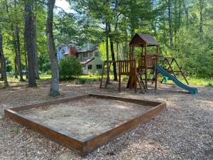 un parque infantil con tobogán y columpios en Cozy Attitash Getaway-Hotel Room-Pool-Hot Tub, en Bartlett