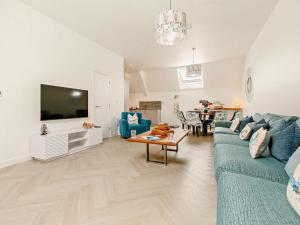 Una sala de estar con un sofá azul y un televisor. en 3 Bed in Newquay 90070, en Newquay