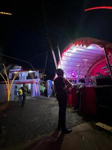 a man standing in front of a tent at night at Villa RISO in Boossa +17 photos