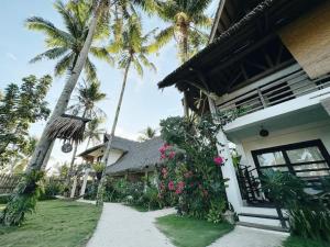 a house with palm trees in front of it at Buddha Resort in Catagnan