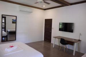 a bedroom with a bed and a desk and a television at Buddha Resort in Catagnan +61 photos