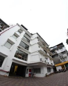 a large white building with a lot of windows at Mayor Hotel in Siliguri